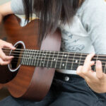 アコースティックギターを弾く中学生